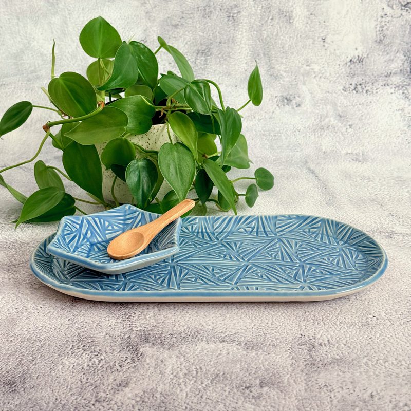 Long blue oval tray with spoon and small dish.